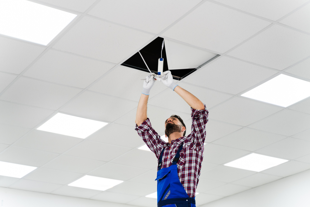 Full,Length,Portrait,Of,Electrician,On,Stepladder,Installs,Lighting,To