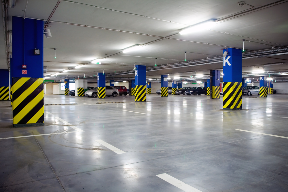 Parking,Garage,,Underground,Interior,With,A,Few,Parked,Cars.,Neon